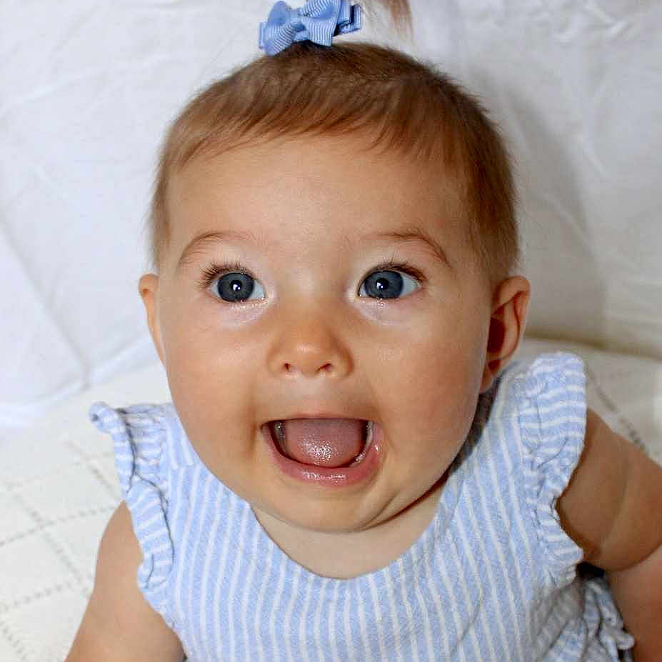 Mylee joined the competition — help win amazing prizes! adorable, baby, blue_eyes, bow, child, closeup, cute, dress, happy, head_accessory, infant, innocent, joyful, portrait, sitting, smiling, soft_texture, striped_clothing, white_background, young_child