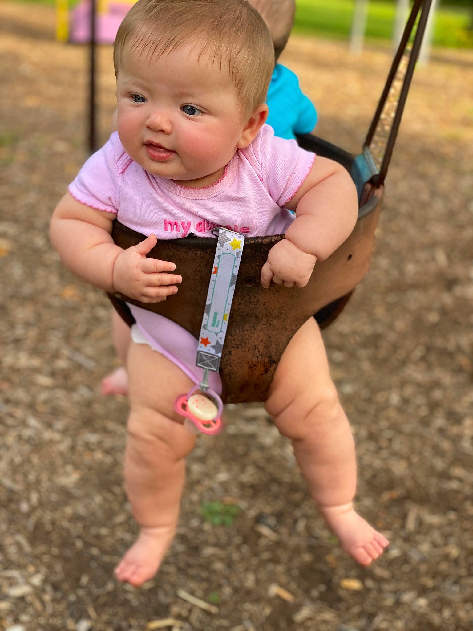 Callie joined the competition — help win amazing prizes! baby, child, fun, grass, leg, outdoor_play_equipment, person, pink, plant, play, playground, public_space, recreation, skin, smile, soil, summer, swing, toddler, vacation