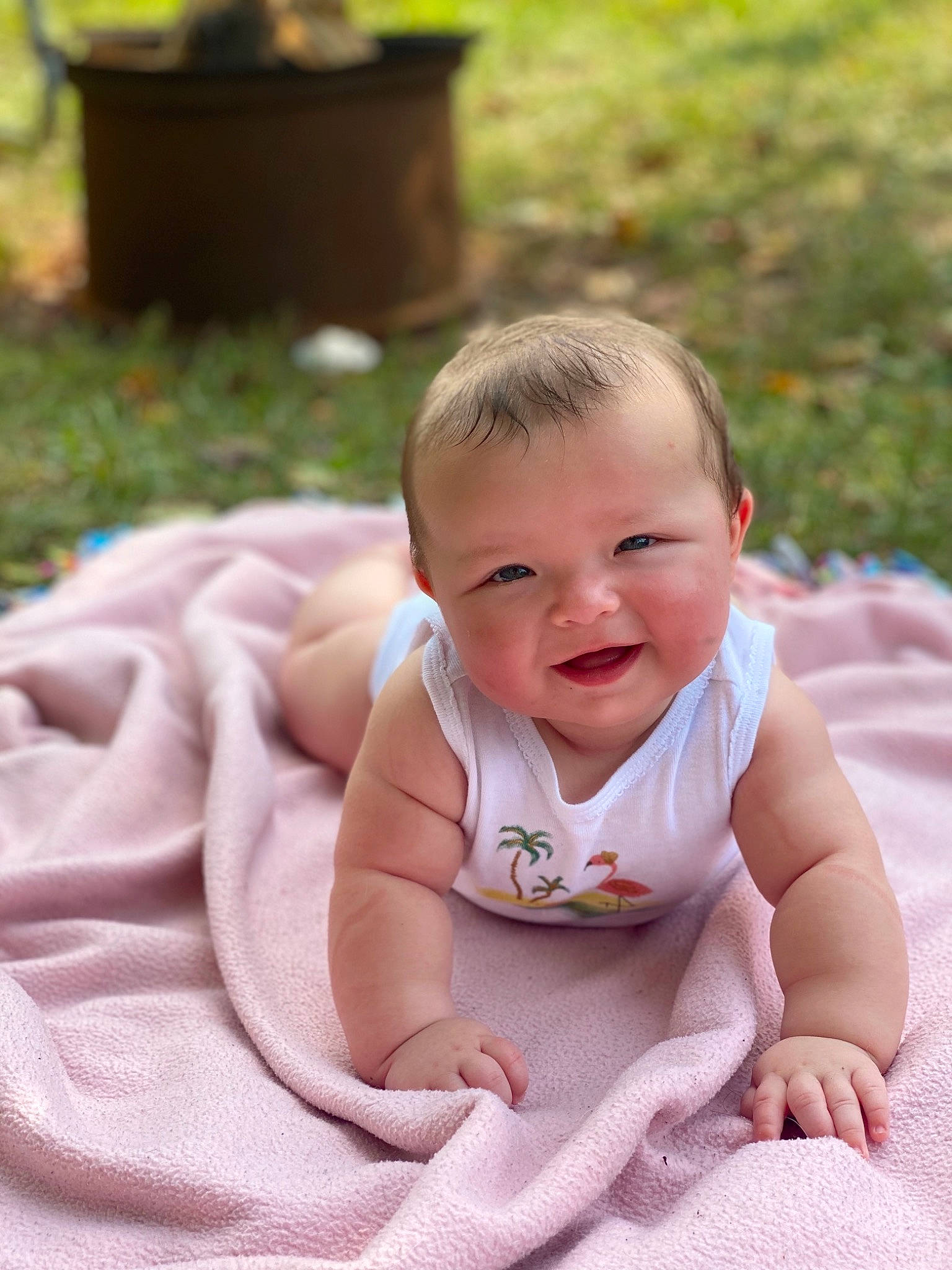 Clara is registered to the contest to win money with this photo: baby, cheek, child, face, grass, person, photograph, photography, pink, sitting, skin, smile, toddler, tummy_time, vacation