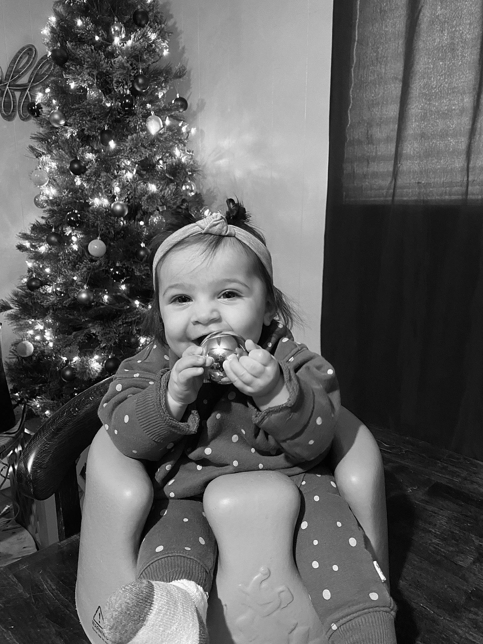 Baylor is registered to the contest to win money with this photo: baby, black, black_and_white, child, christmas_decoration, christmas_ornament, christmas_tree, event, gesture, happy, holiday, joy, monochrome, monochrome_photography, ornament, person, sitting, style, toddler, tradition