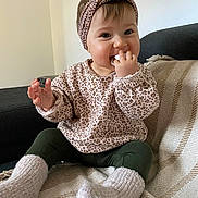 Valentina a rejoint le concours — aidez-le/la à gagner de superbes lots ! baby, child, infant, pacifier, headband, leopard_print, sweater, socks, blanket, couch, indoor, smiling, cute, seated, cozy, happy, person, portrait, home, soft_lighting