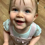 Alexis is registered to the contest to win money with this photo: toddler, child, smiling, happy, face, eyes, pink_clothing, overalls, indoor, wooden_floor, cute, portrait, baby, person, hair, looking_up, small_hands, cheerful, apparel, one_child