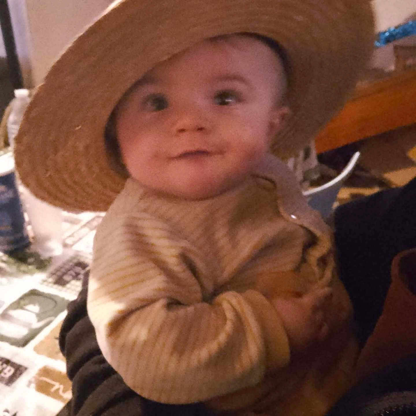 Masséo a rejoint le concours — aidez-le/la à gagner de superbes lots ! baby, background, child, cozy, curious, cute, dim_lighting, face, hand, hat, holding, indoor, infant, person, portrait, smile, straw_hat, striped_clothing, sweater, warm_clothing