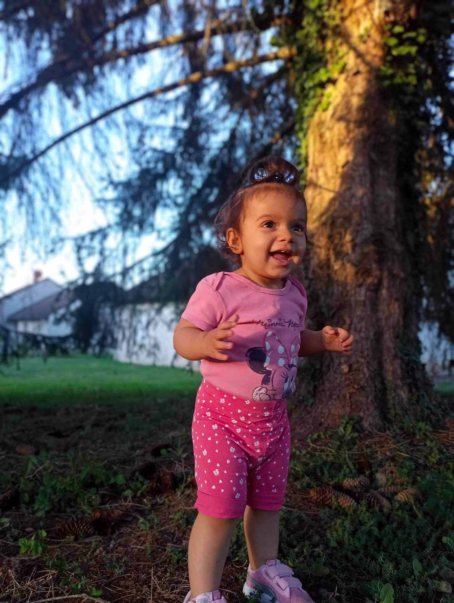 Nawell participe au concours pour gagner de l'argent avec cette photo : baby, child, flash_photography, forest, fun, grass, happy, leaf, leisure, magenta, people_in_nature, person, plant, recreation, sitting, sky, smile, toddler, tree, trunk