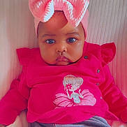 Miya participe au concours pour gagner de l'argent avec cette photo : baby, child, infant, pink_bow, pink_clothing, cartoon_print, blanket, soft_texture, cute, portrait, indoors, seated, serious_expression, headband, chubby_cheeks, clothing, person, face, young_child, cozy