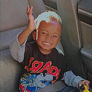 Kamari joined the competition — help win amazing prizes! child, smiling, car_seat, seatbelt, toy_car, dinosaur_shirt, happy, boy, vehicle_interior, casual_clothing, sunlight, portrait, sitting, hand_raised, young, cute, short_hair, playful, daylight, seat