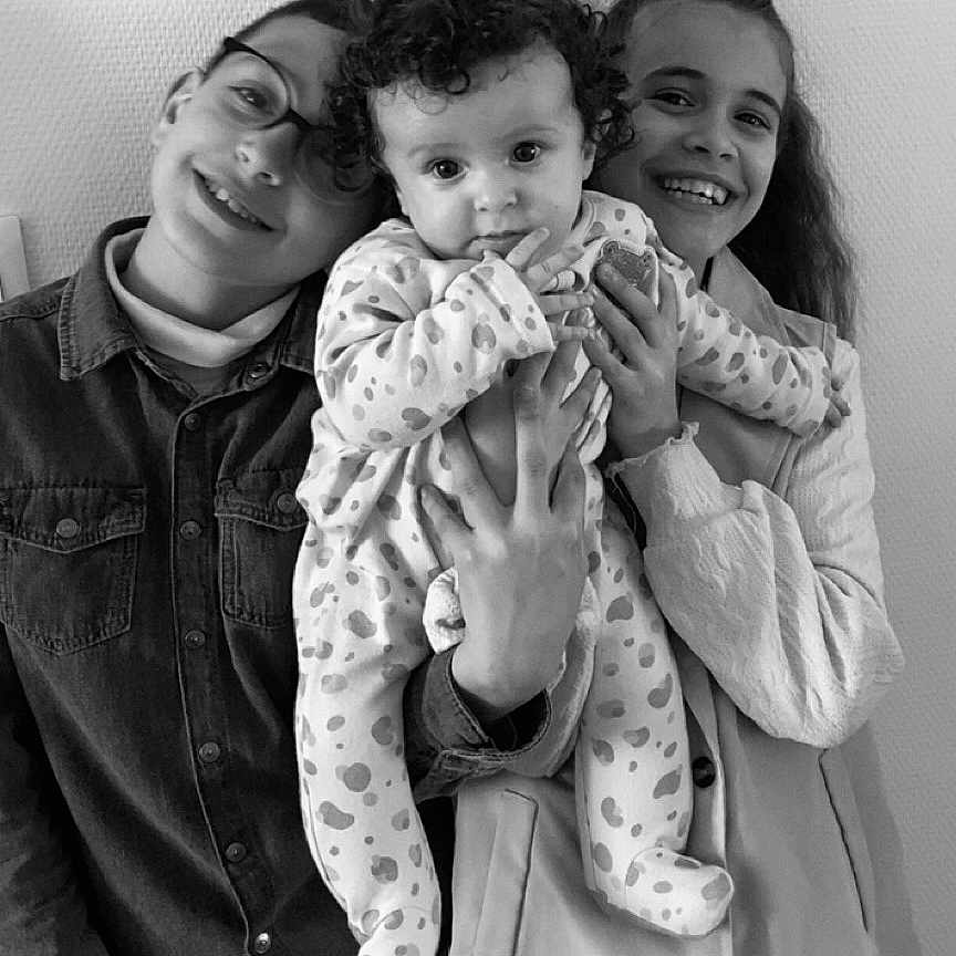Manël a rejoint le concours — aidez-le/la à gagner de superbes lots ! baby, black_and_white, casual_clothing, child, children, curly_hair, cute, family, glasses, happy, holding_baby, indoor, love, person, polka_dot, portrait, sibling, smiling, toddler, young