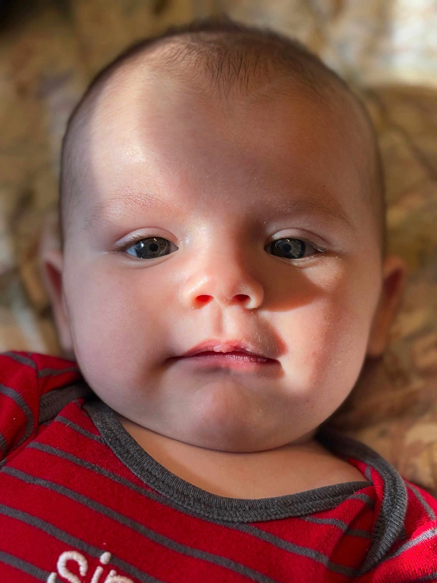 Isaiah is registered to the contest to win money with this photo: baby, infant, face, portrait, closeup, child, red_clothing, striped_shirt, skin, eyes, mouth, soft_lighting, indoors, cute, young, person, expression, head, cheeks, newborn