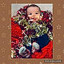 baby, tinsel, festive, holiday, red_blanket, smiling, tongue_out, cozy, cute, indoor, christmas, decorations, child, person, sock, blue_pants, face, happy, celebration, cute_expression
