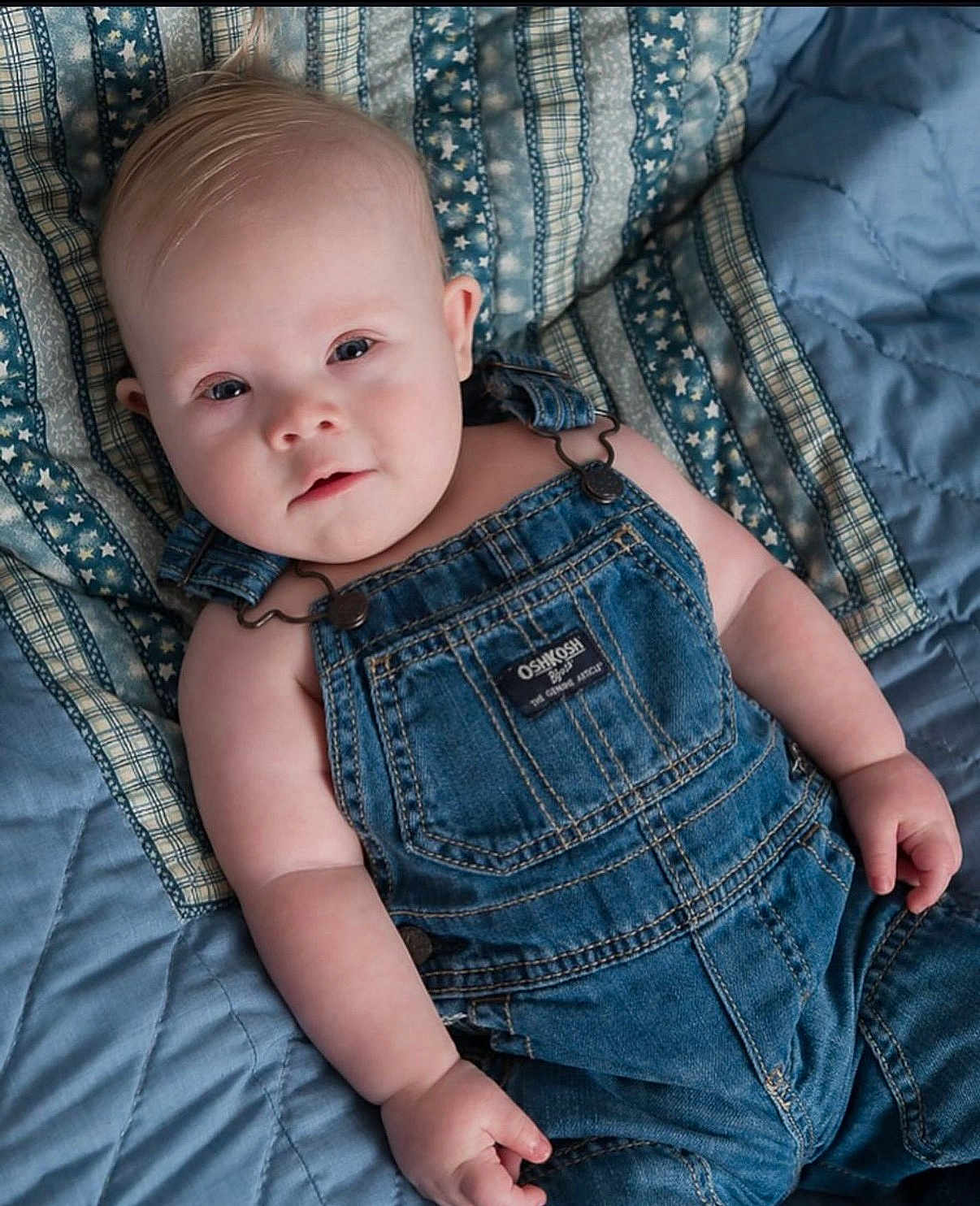 Cooper joined the competition — help win amazing prizes! baby, infant, denim_overalls, blue_quilt, bed, lying_down, child, cute, soft_lighting, portrait, face, skin, hand, clothing, fabric, baby_fashion, casual, indoor, newborn, young_child