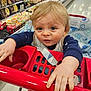 toddler, child, shopping_cart, supermarket, blue_eyes, blonde_hair, clothing, baby, hand, grocery_store, aisle, food_container, face, curious, infant, retail, shopping, cute, indoor, person