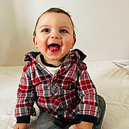 Nino a rejoint le concours — aidez-le/la à gagner de superbes lots ! child, baby, toddler, smiling, tongue_out, plaid_shirt, red_plaid, sitting, indoors, white_background, portrait, cute, happy, eyes, hands, jeans, sock, cozy, casual_clothing, playful