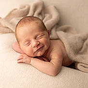 Agathe participe au concours pour gagner de l'argent avec cette photo : newborn, baby, sleeping, smiling, blanket, soft_texture, cozy, infant, peaceful, resting, skin, head, hand, portrait, closeup, warm_lighting, fabric, cute, child, indoors
