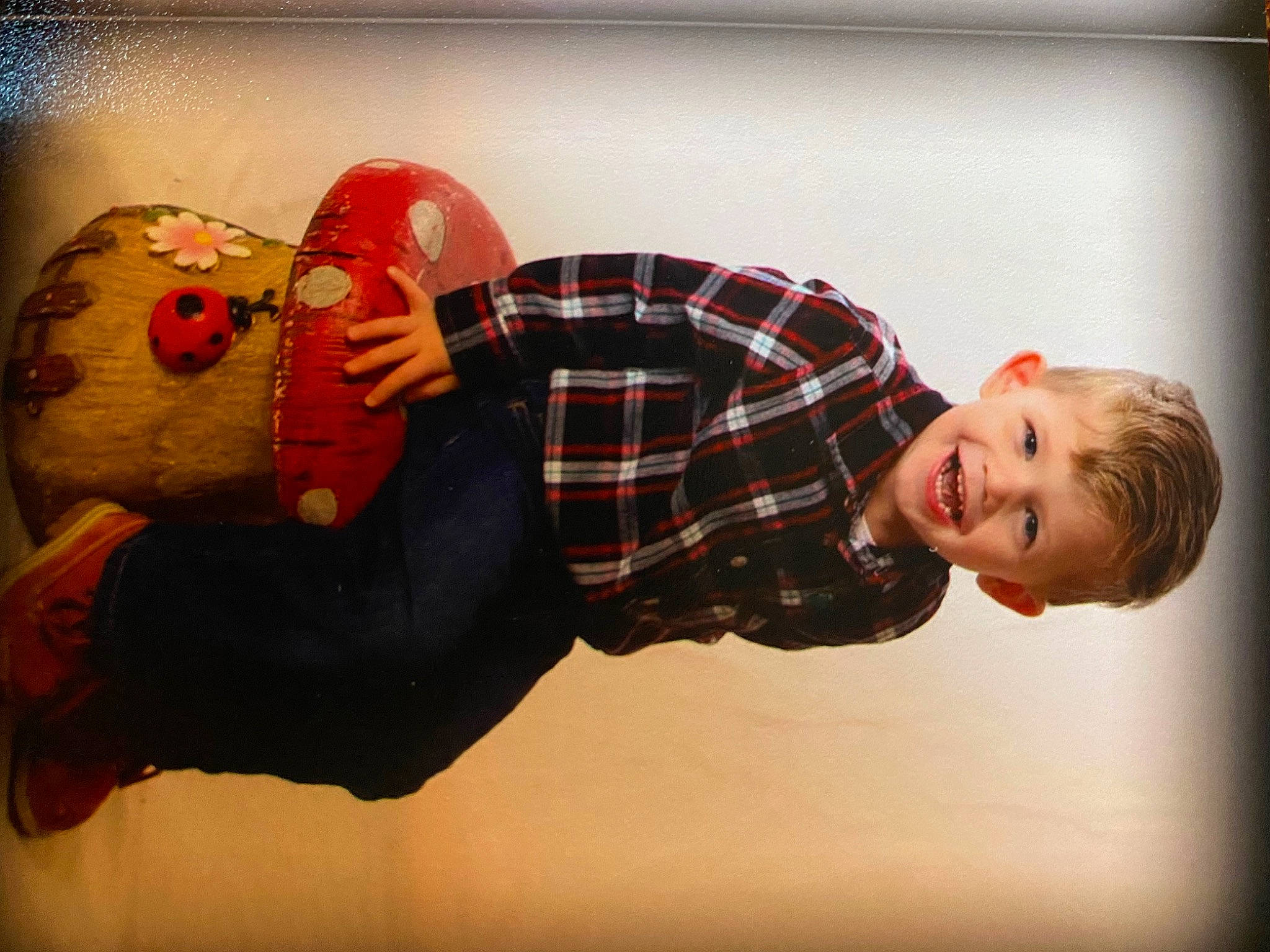 Jace joined the competition — help win amazing prizes! art, carmine, child, elbow, flash_photography, fun, gesture, happy, joy, pattern, person, personal_protective_equipment, plaid, plush, room, sitting, smile, stuffed_toy, tartan, toddler