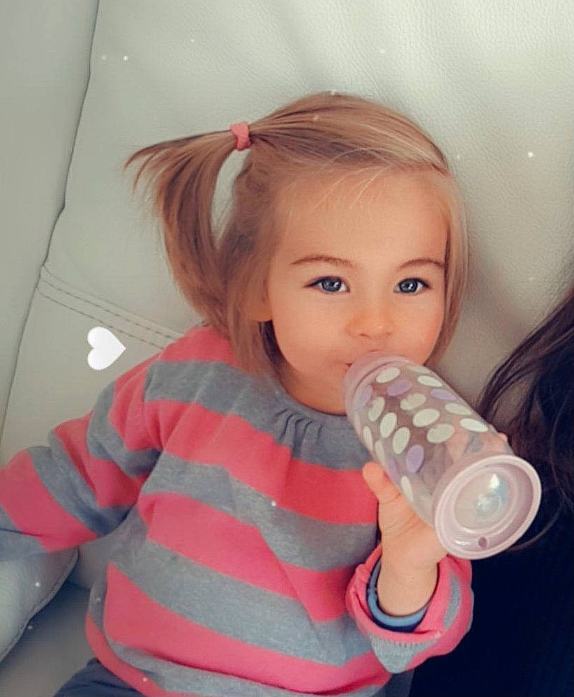 Bella a rejoint le concours — aidez-le/la à gagner de superbes lots ! baby_bottle, baby_toddler_clothing, cheek, child, drink, drinkware, eyelash, finger, hairstyle, happy, iris, lip, nail, person, pink, plastic_bottle, skin, sleeve, tableware, toddler