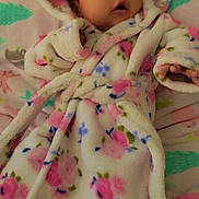 Emma joined the competition — help win amazing prizes! baby, infant, robe, floral_pattern, blanket, bed, soft_fabric, cute, child, indoors, sleepwear, warm, person, young, comfortable, resting, headwear, expression, lying_down, skin