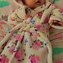 baby, infant, robe, floral_pattern, blanket, bed, soft_fabric, cute, child, indoors, sleepwear, warm, person, young, comfortable, resting, headwear, expression, lying_down, skin