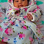 Emma is registered to the contest to win money with this photo: baby, infant, hooded_robe, floral_pattern, blanket, animal_print, cozy, cute, child, sleepwear, soft, indoors, laying_down, small_hands, peaceful, portrait, warm, comfort, baby_clothing, relaxing