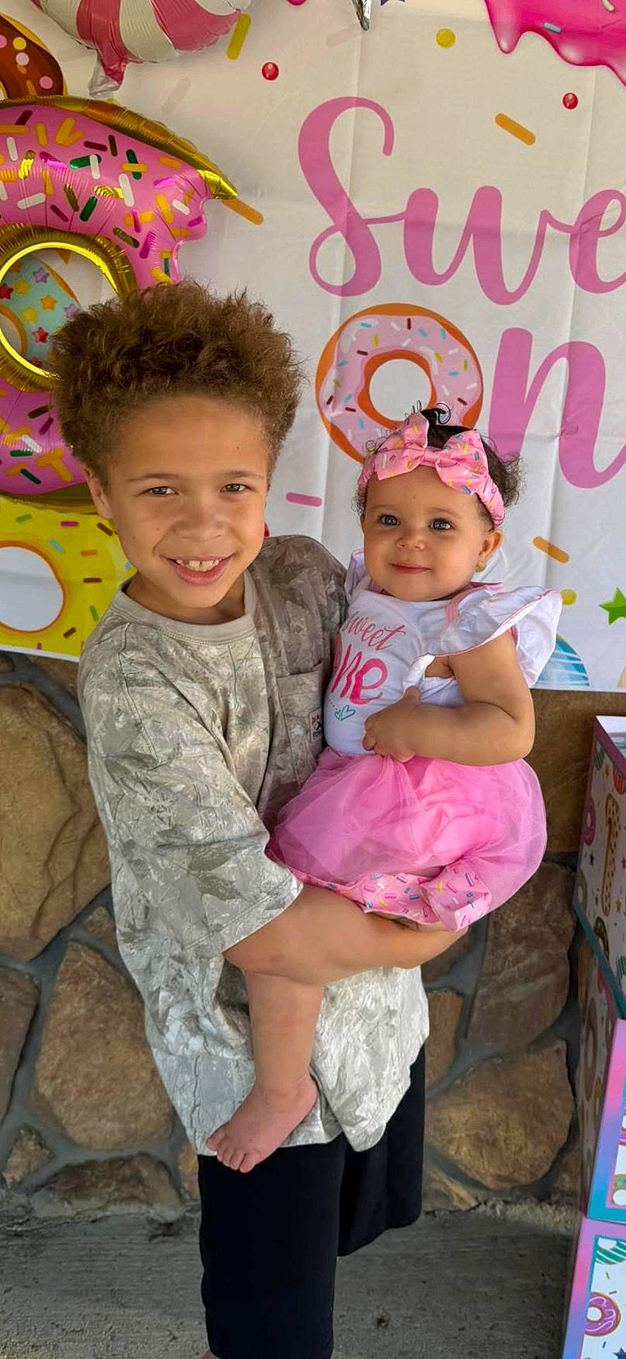 Nyah joined the competition — help win amazing prizes! baby, background, banner, boy, celebration, child, cute, decorations, donut, family, girl, happy, headband, holding, outdoor, party, pink, portrait, smiling, tutu