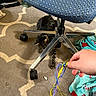 cat, cats, tabby_cat, pet, animal, indoor, home, carpet, office_chair, chair_wheels, under_chair, blanket, hand, string, toy, playing, hiding, floor, furniture, cozy
