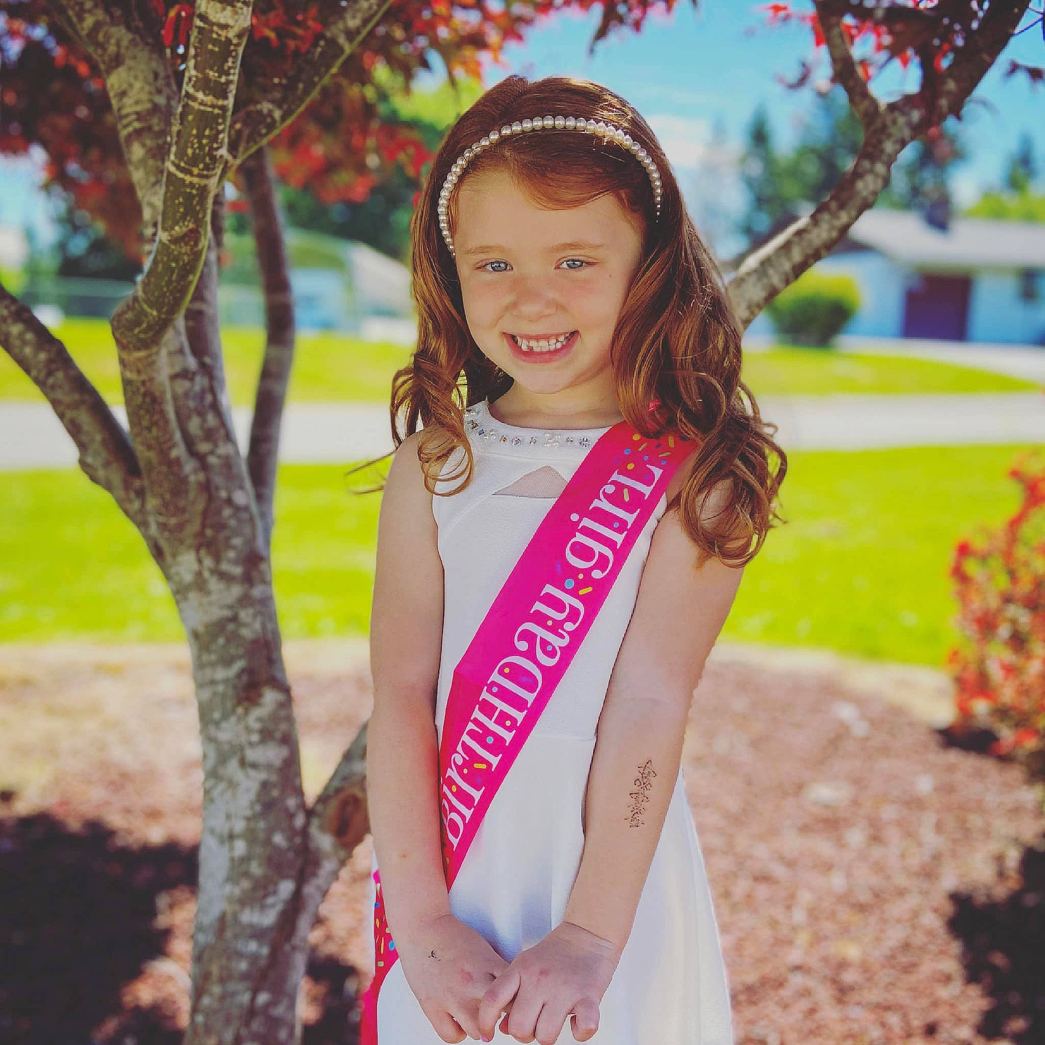 Emma is registered to the contest to win money with this photo: branch, clothing, dress, face, facial_expression, flash_photography, grass, hair, hairstyle, happy, head, joy, leisure, outerwear, people_in_nature, person, plant, smile, street_fashion, tree