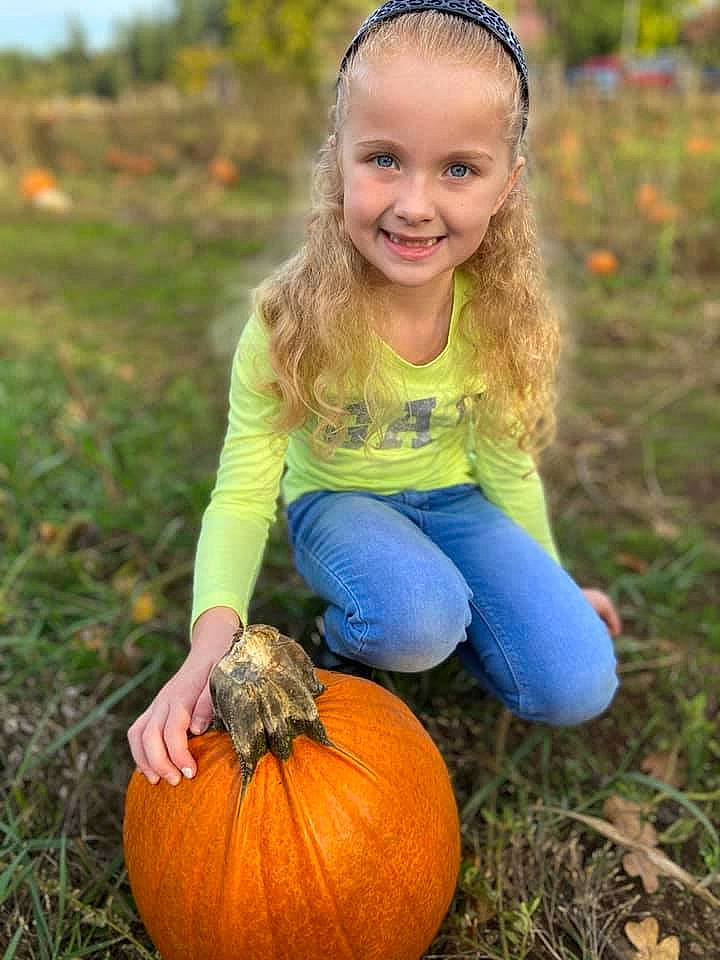 Macy is registered to the contest to win money with this photo: calabaza, clothing, cucurbita, eye, facial_expression, gourd, grass, hair, happy, head, human_body, jeans, joy, leaf, nature, people_in_nature, person, photograph, plant, pumpkin