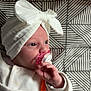 Léna a rejoint le concours — aidez-le/la à gagner de superbes lots ! baby, infant, pacifier, white_clothing, white_bow, blanket, patterned_background, hand, face, headwear, cute, lying_down, indoors, soft_texture, orange_clip, newborn, child, person, pacifier_clip, closeup