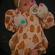 Ivy is registered to the contest to win money with this photo: baby, infant, pacifier, headband, bow, mittens, pumpkin_pattern, orange, white_socks, cute, sleepy, clothing, portrait, child, newborn, soft_lighting, dark_background, cozy, festive, small