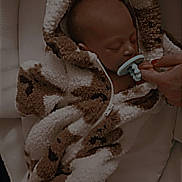 Ivy joined the competition — help win amazing prizes! newborn, baby, pacifier, hand, jacket, brown, white, cozy, sleeping, infant, cushion, baby_carrier, soft, warm, child, person, sleep, clothing, closeup, resting