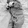 baby, newborn, sleeping, striped_clothing, onesie, blanket, quilted, infant, cute, peaceful, resting, soft, child, portrait, monochrome, black_and_white, small, wrapped, hand_mittens, lying_down