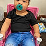 Raniah joined the competition — help win amazing prizes! baby, black_shirt, blue_jeans, bow, carpet, child, curly_hair, fashion, headband, indoor, infant, pacifier, photography, pink, portrait, sitting, smiling, stroller, toddler, wall