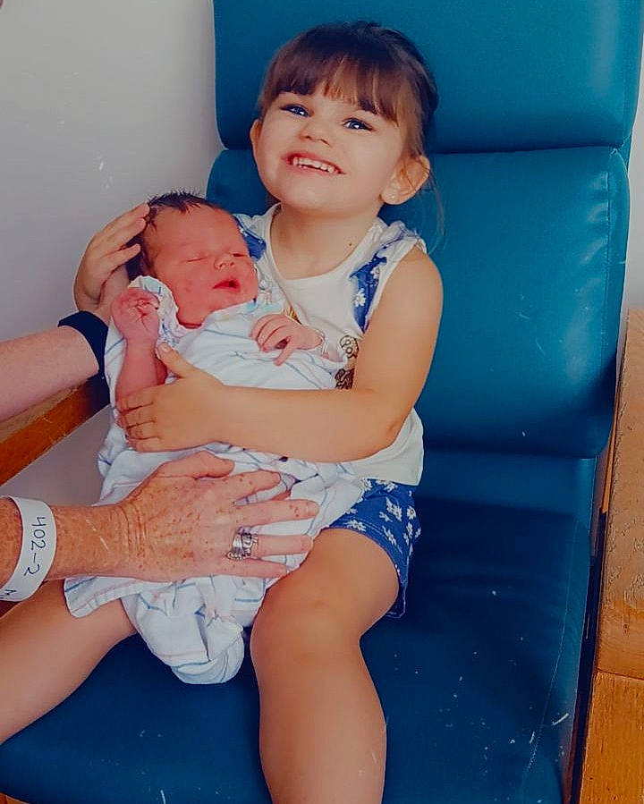 Octavia is registered to the contest to win money with this photo: azure, baby, comfort, eye, facial_expression, finger, gesture, happy, human_body, joint, joy, knee, mouth, person, shorts, shoulder, skin, smile, stomach, thigh