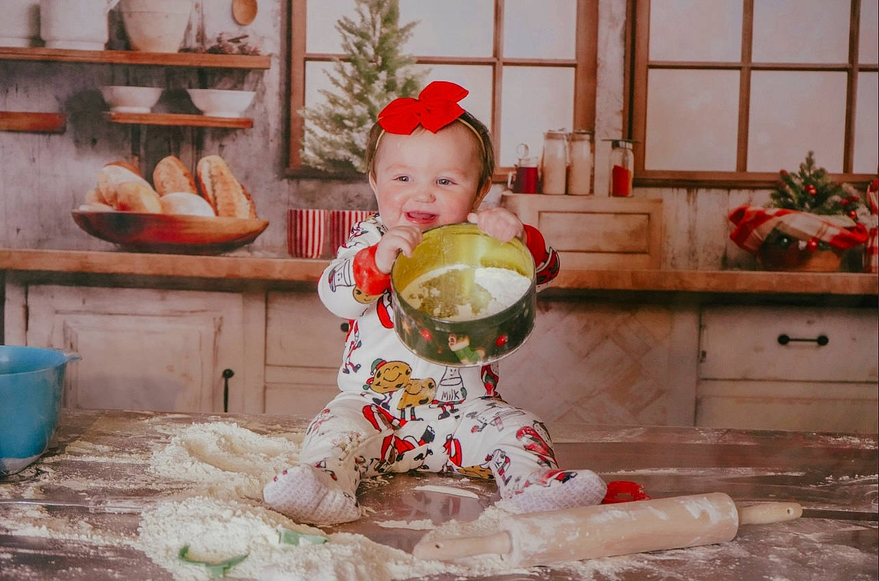 Everleigh joined the competition — help win amazing prizes! baby, child, christmas_eve, comfort_food, cook, event, hat, holiday, houseplant, kitchen, peach, person, pink, plant, porcelain, room, sitting, textile, toddler, toy