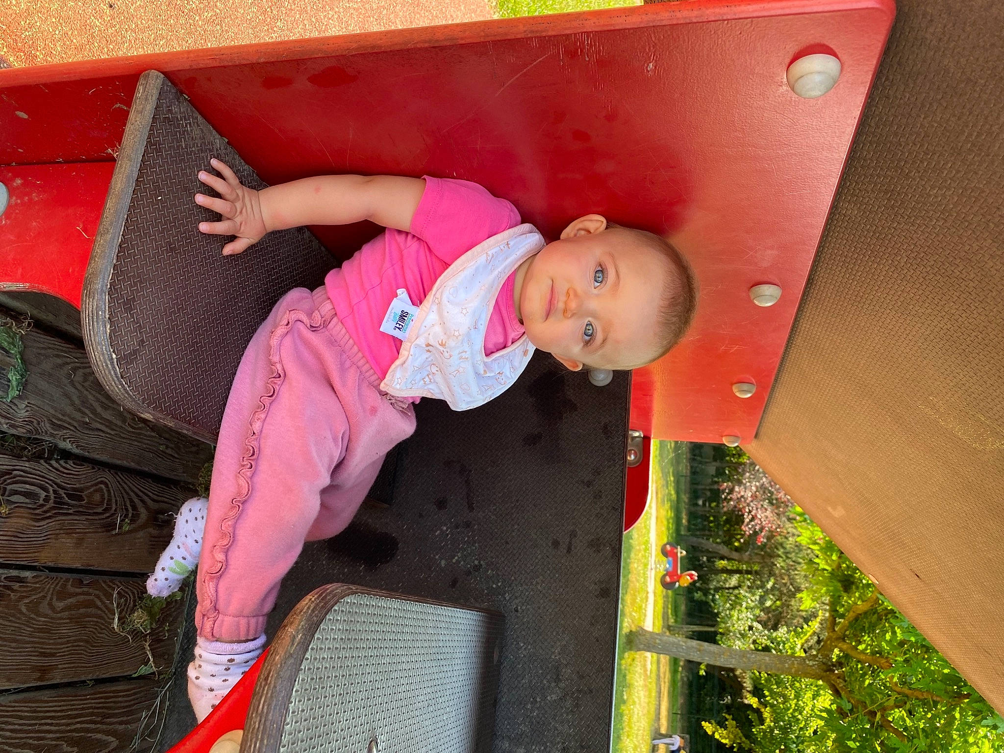 Nelya participe au concours pour gagner de l'argent avec cette photo : baby, baby_toddler_clothing, child, fun, grass, happy, hat, human_settlement, leaf, leisure, magenta, outdoor_play_equipment, person, pink, plant, play, red, sitting, toddler, vehicle_door