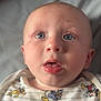 baby, infant, face, blue_eyes, onesie, clothing, cartoon_characters, pluto, donald_duck, mickey_mouse, expression, cute, child, portrait, skin, head, mouth, lying_down, soft_light, indoor
