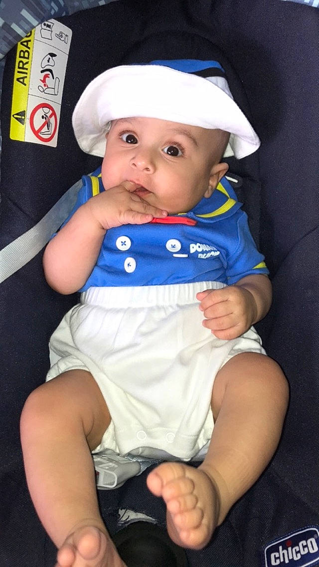 Ismael a rejoint le concours — aidez-le/la à gagner de superbes lots ! baby, baby_products, baby_toddler_clothing, cap, chair, cheek, child, costume_hat, electric_blue, fashion_accessory, happy, headwear, human_leg, knee, lap, pattern, person, sitting, sleeve, thigh