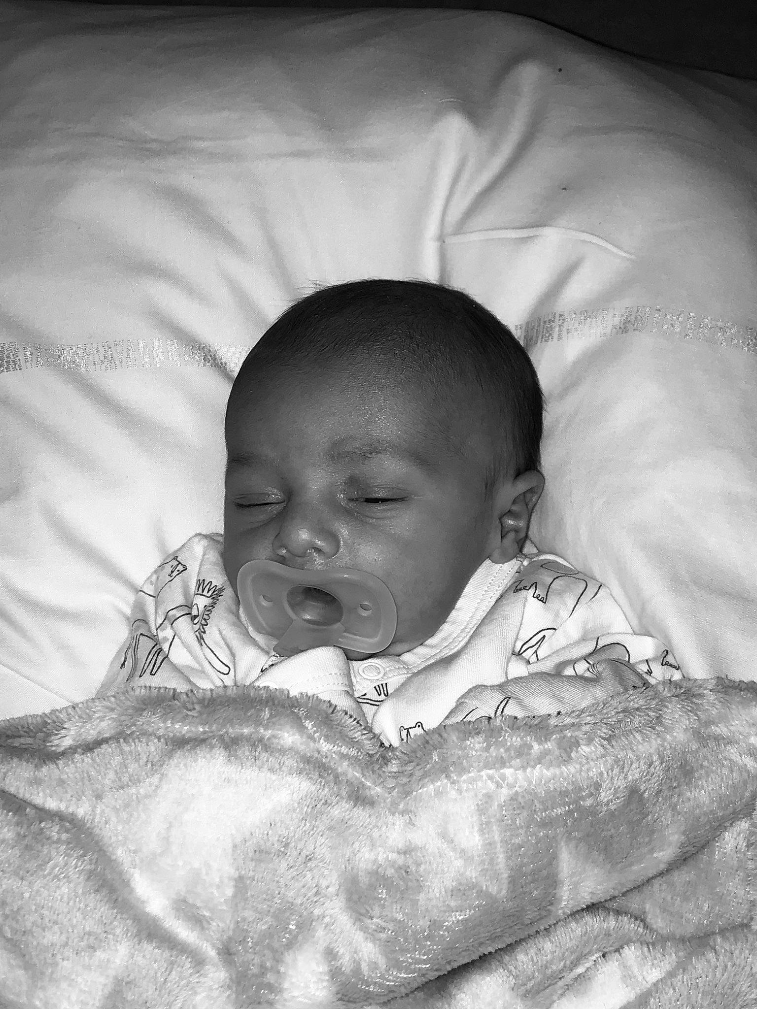 Ismaël participe au concours pour gagner de l'argent avec cette photo : baby, bedtime, cheek, comfort, darkness, eye, eyebrow, flash_photography, happy, iris, linens, monochrome, monochrome_photography, mouth, nose, person, skin, sleeve, smile, textile