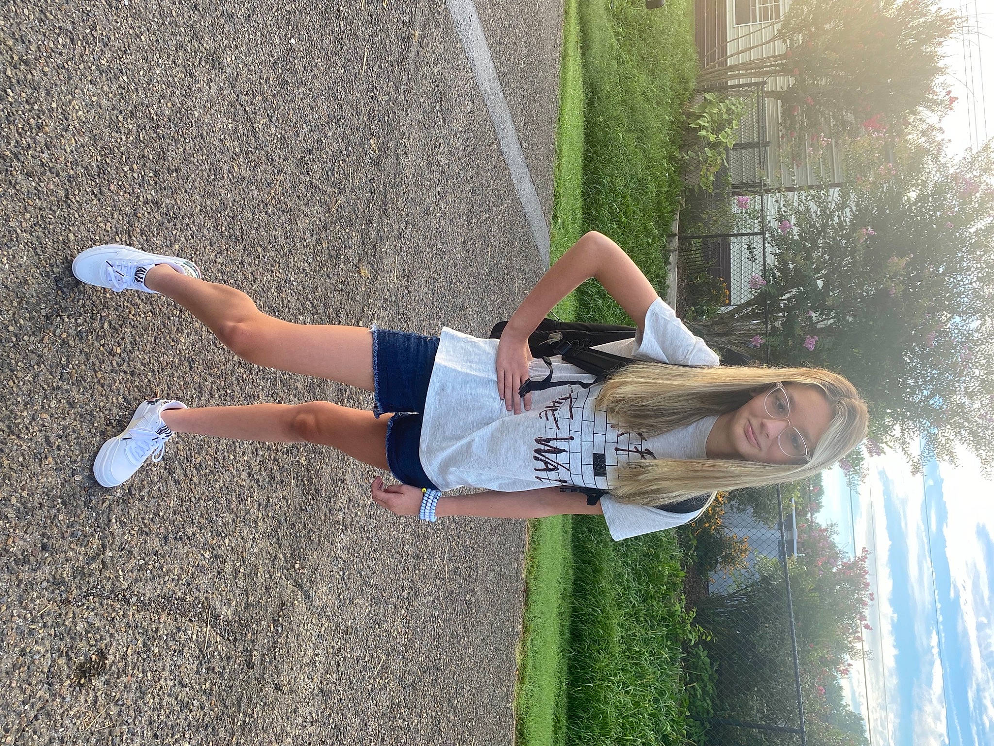 Sarah is registered to the contest to win money with this photo: calf, fun, grass, human_leg, knee, leisure, people_in_nature, person, plant, recreation, shadow, shorts, sidewalk, sports_uniform, sportswear, t_shirt, thigh, tree, waist