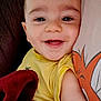 Giuliann a rejoint le concours — aidez-le/la à gagner de superbes lots ! baby, smiling, face, child, yellow_shirt, blanket, cushion, cartoon_character, happy, closeup, indoor, person, infant, cute, portrait, skin, head, eyes, mouth, arm