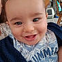 baby, smiling, face, closeup, infant, child, blue_clothing, blanket, indoors, happy, expression, person, cute, eyes, mouth, teeth, head, sitting, toddler, clothing