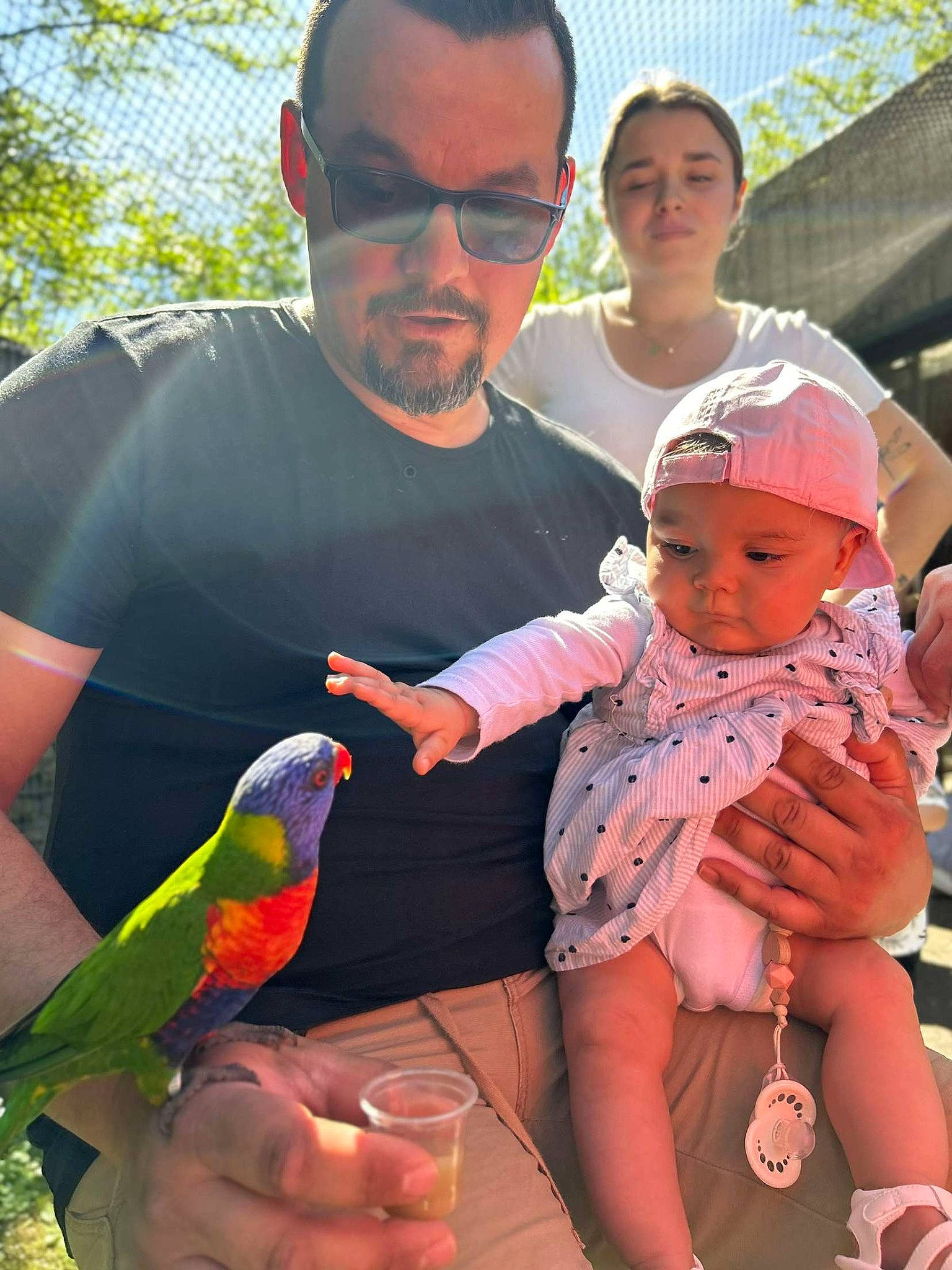 Ynaïa a rejoint le concours — aidez-le/la à gagner de superbes lots ! baby, beak, bird, child, event, eyewear, fun, hand, happy, hat, headwear, lap, leisure, mouth, parakeet, parrot, person, recreation, sitting, toddler