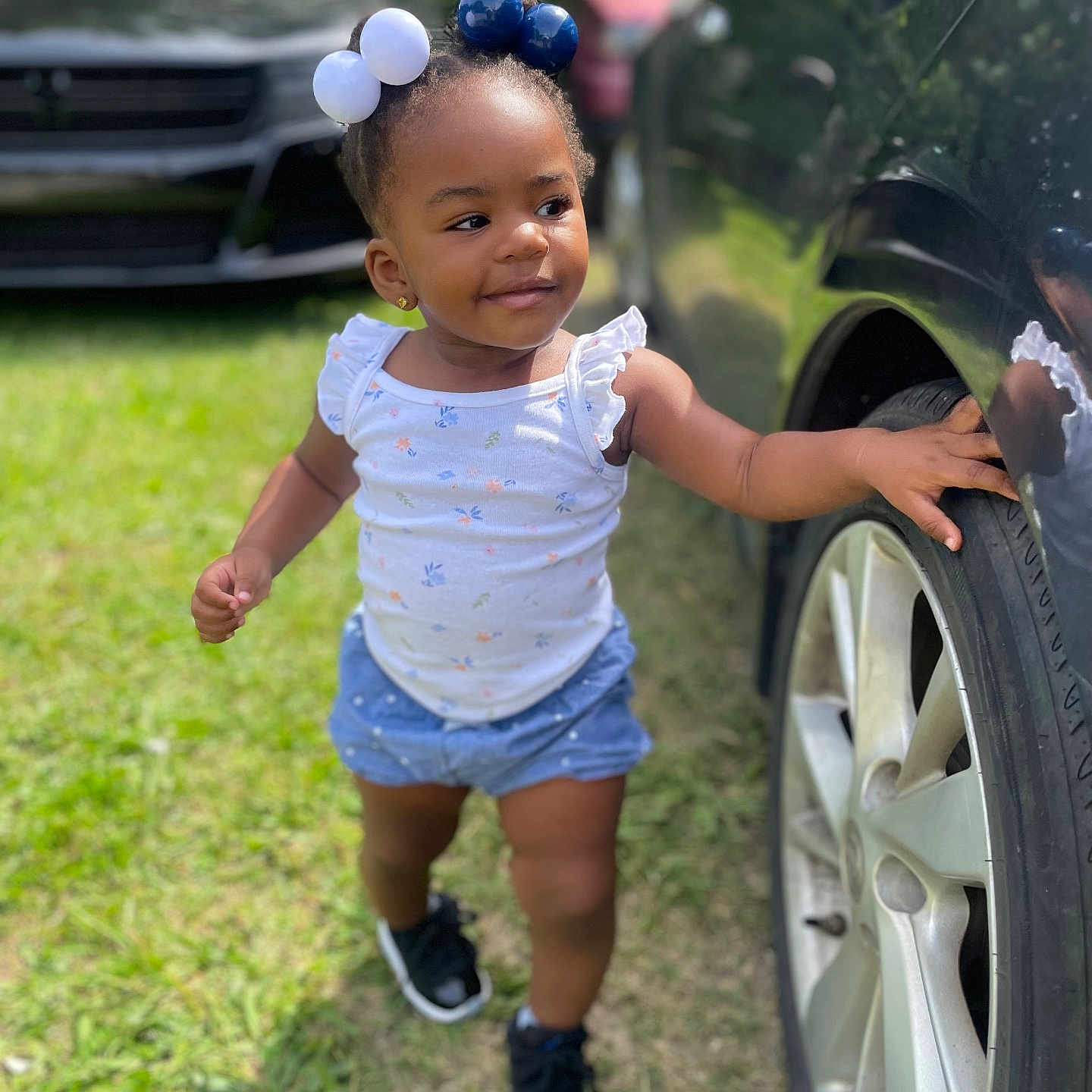 Khloe joined the competition — help win amazing prizes! alloywheel, baby, car, carwheel, clothing, dress, face, grass, head, machine, person, photography, plant, portrait, shorts, spoke, tire, transportation, vehicle, wheel