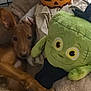 puppy, dog, plush_toy, pumpkin, frankenstein_toy, bed, cage, brown_dog, pet, cozy, indoor, cute, animal, soft, resting, stuffed_animal, holiday, halloween, toy, relaxed