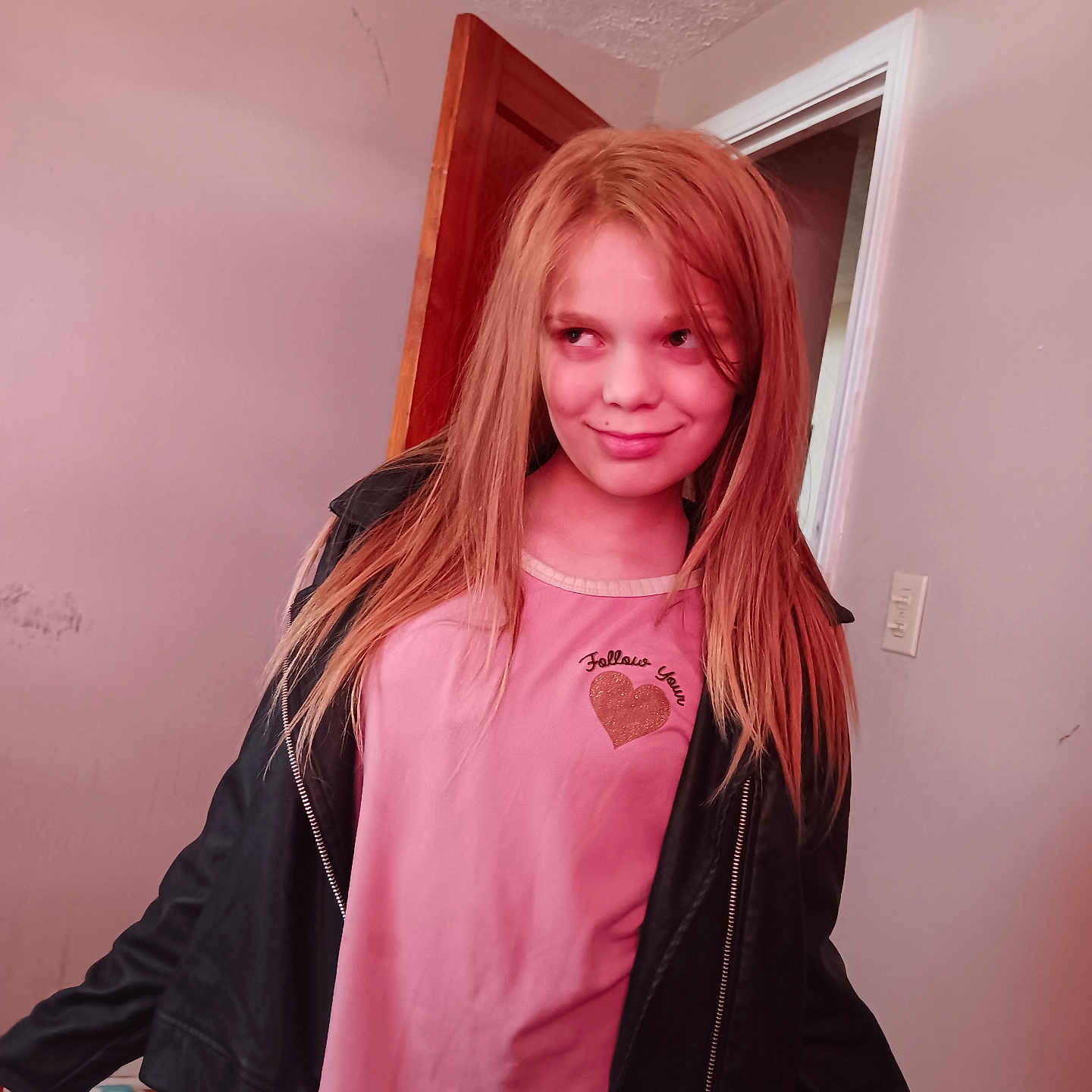 Izzyana Lute joined the competition — help win amazing prizes! black_jacket, casual_clothing, child, door, girl, home, indoor, light_switch, long_hair, mischievous_expression, patterned_pants, person, pink_shirt, portrait, room, smile, standing, wall, wooden_floor, young