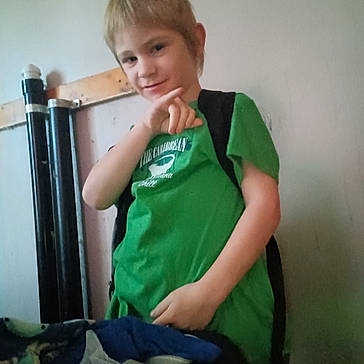 Allen Jr Lute joined the competition — help win amazing prizes! blurry_background, boy, casual, child, clothing, furniture, gesture, green_shirt, household_items, indoor, person, pipes, pose, relaxed, room, short_hair, smile, standing, wall, young