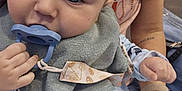 Cole is registered to the contest to win money with this photo: adult, baby, bib, child, closeup, clothing, cozy, cute, fabric, face, hand, holding, indoor, infant, pacifier, pajamas, person, portrait, sitting, skin