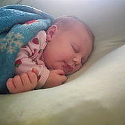 Stella joined the competition — help win amazing prizes! newborn, baby, sleeping, infant, portrait, face, hands, fist, blanket, blue_blanket, pink_clothing, strawberry_pattern, bed, bedding, cozy, indoors, closeup, peaceful, resting, soft_lighting