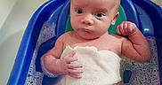 Jackson is registered to the contest to win money with this photo: baby, bath, bathroom, blue_bath_seat, bubbles, child, curious, face, foam, head, indoors, infant, person, sitting, skin, small_hand, towel, water, wet, young
