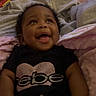 baby, smiling, infant, blanket, clothing, shirt, face, happy, indoor, person, cute, child, lying_down, cozy, diaper, snack, cookies, chips_ahoy, black_shirt, glitter