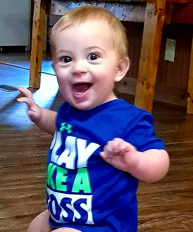 Callum is registered to the contest to win money with this photo: baby_toddler_clothing, cheek, cool, eye, finger, gesture, happy, head, human_body, iris, mouth, nose, person, skin, sleeve, smile, standing, thumb, toddler, vertebrate